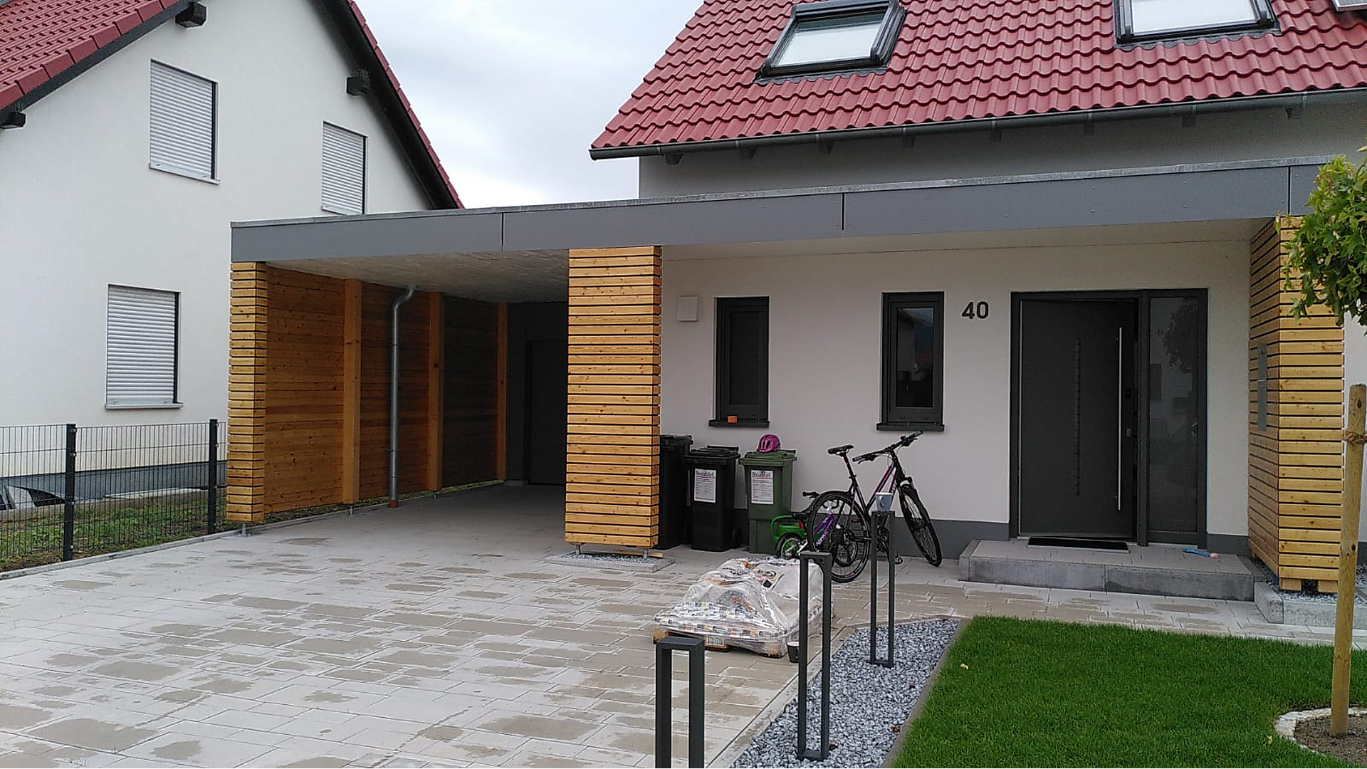 Holzcarport – Referenzprojekt Moderner Holzcarport mit Flachdach an einem Wohnhaus