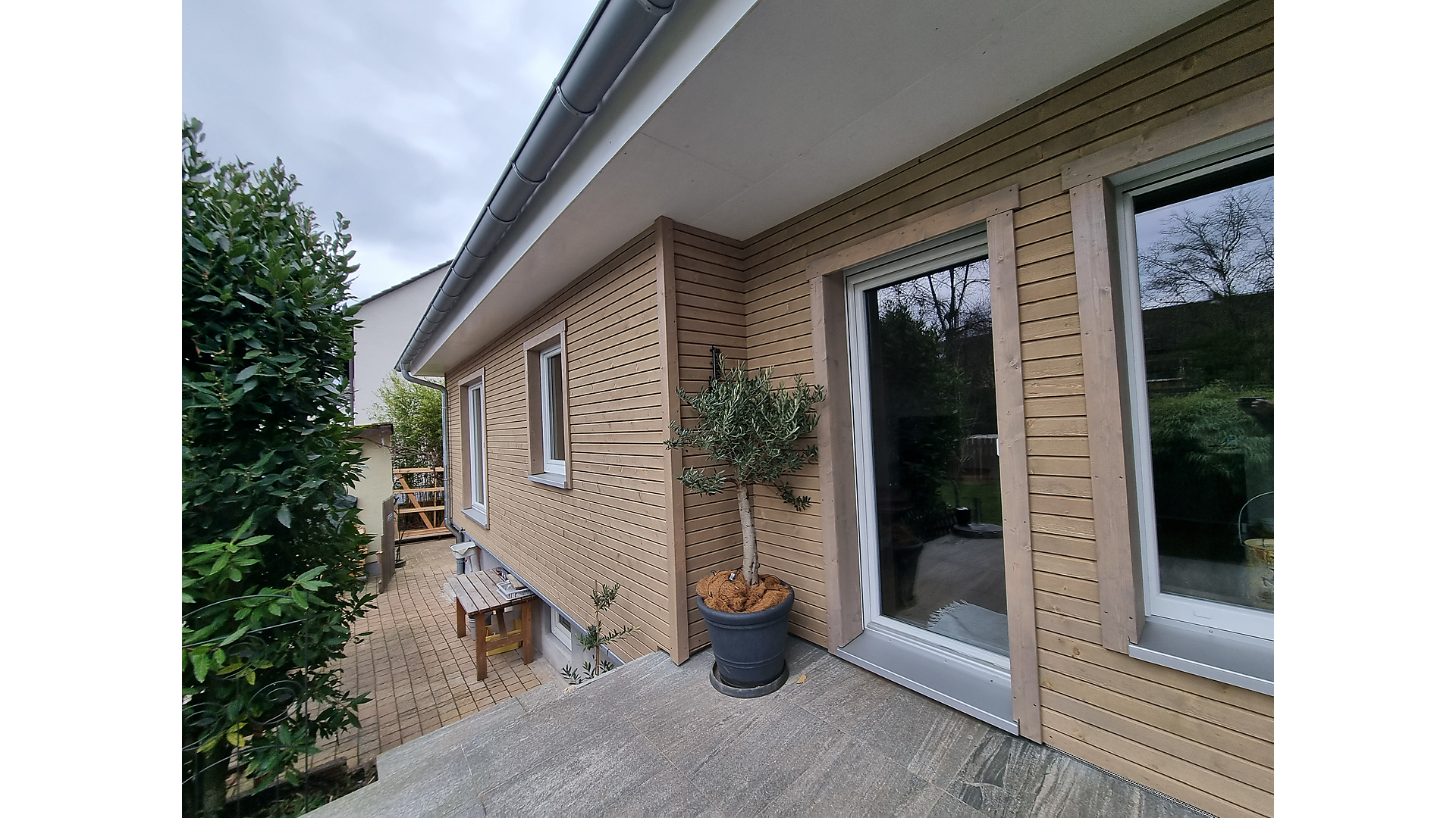 Holzfassade mit horizontaler Holzverschalung an einem Wohnhaus