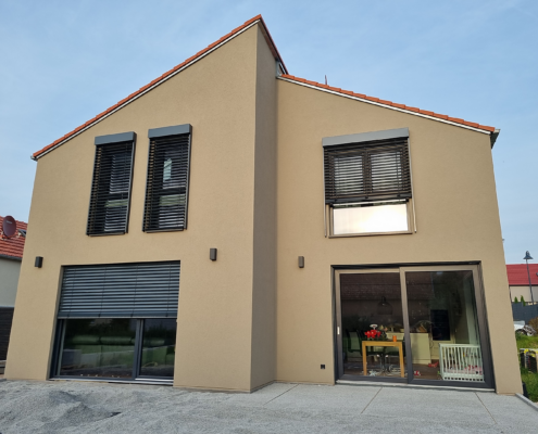Moderner Holzrahmenbau – Einfamilienhaus Moderner Holzrahmenbau mit verputzter Fassade und großen Fensterflächen