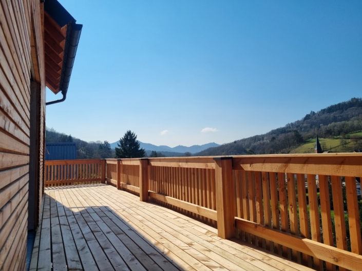 Holzbalkon aus Holz an Einfamilienhaus in der Südpfalz mit Überdachung und Holzgeländer