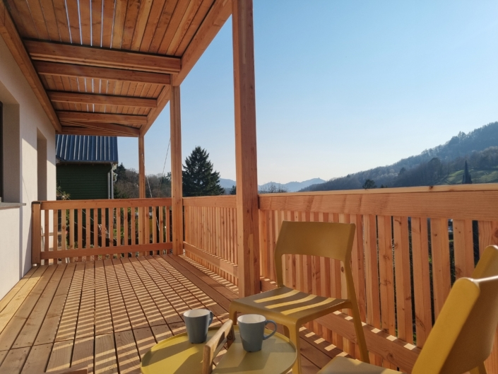 Holzbalkon aus Holz an Einfamilienhaus in der Südpfalz mit Überdachung und Holzgeländer