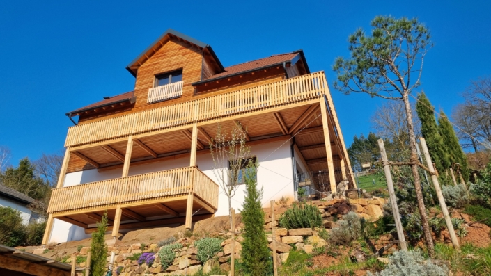 Holzbalkon aus Holz an Einfamilienhaus in der Südpfalz mit Überdachung und Holzgeländer
